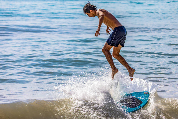 Playa del Carmen, México, 2 de abril de 2023: Surfista saltando de la tabla de surf cuando una ola golpea fuerte en su tabla y lo desequilibra, este deporte acuático es uno de los más bellos. - Foto, imagen