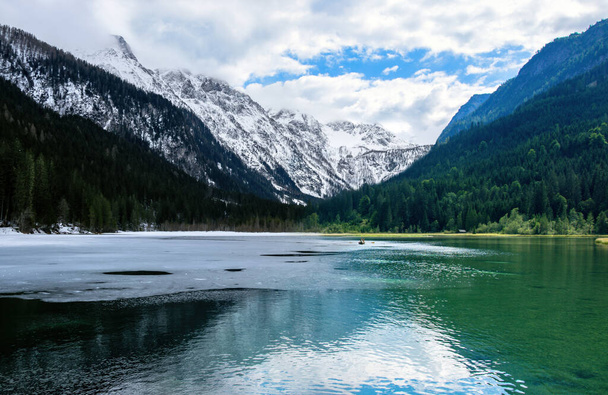 Lac autrichien Jagersee en hiver et en été, gelé avec de la neige et avec des bateaux. Photo modifiée, photomontage. - Photo, image