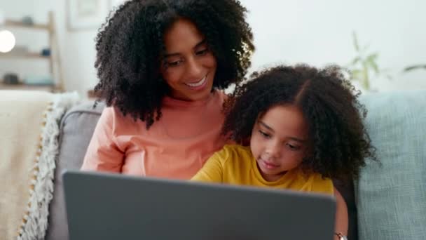 学習、母親と女の子の自宅のリビングルームでソファの上でノートパソコンで笑って、ケアと結合。コンピューター、家庭教育、幸せなママが面白い子供や子供に学習やホームスクールの入力を教える. - 映像、動画
