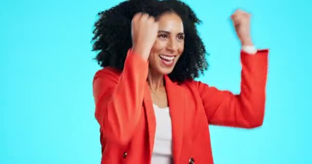 Winner, success and celebration of business woman in studio isolated on a blue background. Fist pump, excited and happy female celebrating winning lottery, competition or prize, good news or bonus - Video