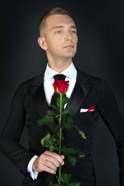 image of tuxedo man at valentines day. tuxedo man at valentines day. tuxedo man hold valentines rose. love occasion for valentines tuxedo man. - Photo, image