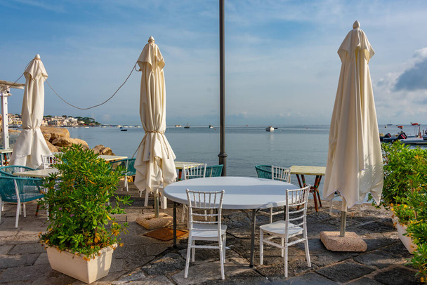 Table and chair on the waterfront of Porto d'Ischia town at Ischia island, Italy. - Fotografie, Obrázek