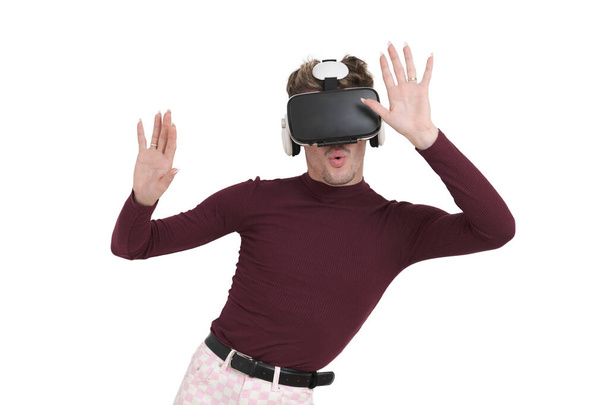 Young caucasian man amazed wearing virtual reality headset. Isolated over white background. - Foto, imagen