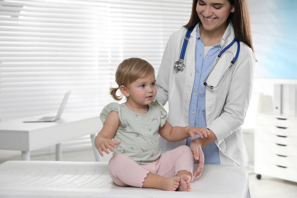 Pediatrician examining cute little baby in clinic - Zdjęcie, obraz