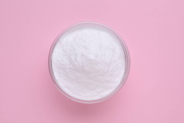 Bowl of sweet powdered fructose on pink background, top view - Φωτογραφία, εικόνα