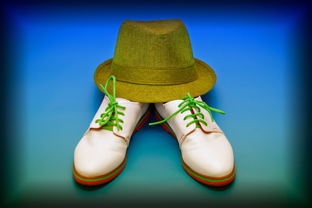 Mode schoenen wit en groen hoed op een blauwe achtergrond - Foto, afbeelding