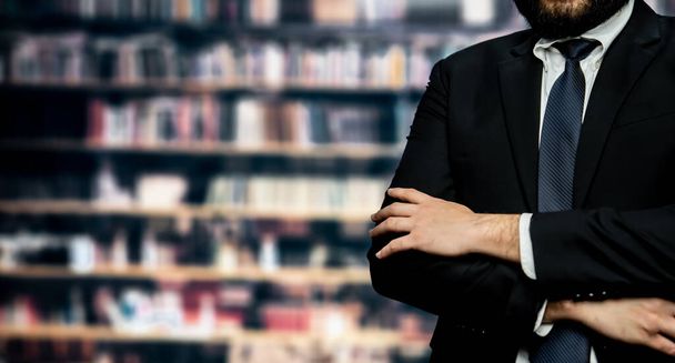 Черный костюмированный бизнесмен или юрист, уверенно стоящий на фоне деловой или юридической школьной библиотеки, концепции профессионализма и успеха в MBA или юридическом образовании. Равновесие - Фото, изображение