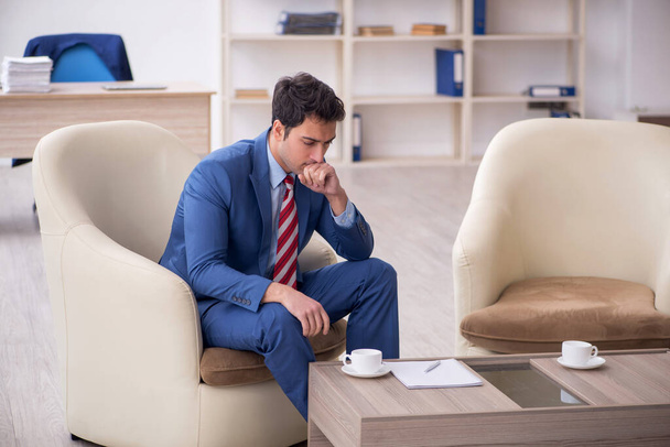 Empleado joven empresario sentado en el lugar de trabajo - Foto, Imagen