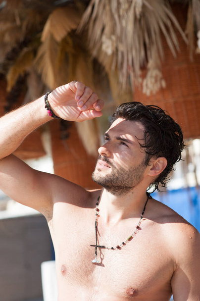 Topless young tropical man outdoor portrait under a palm tree - Zdjęcie, obraz
