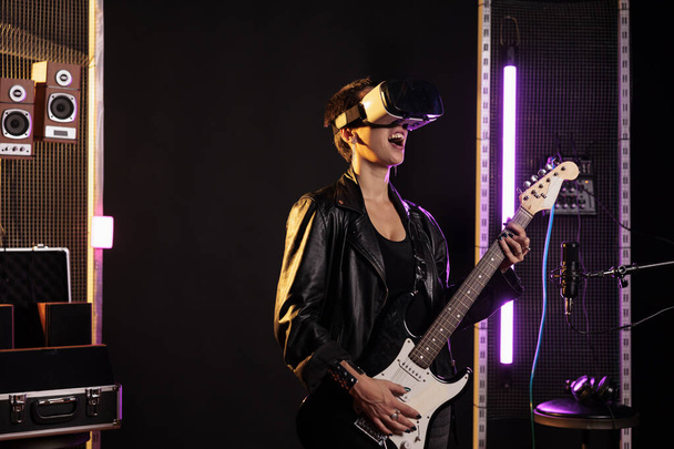 Rockstar з окулярами vr, насолоджуючись симуляцією рок-концерту, граючи важку металеву пісню на електрогітарі в музичній студії. Жінка-музикант виконує гранжевий альбом з використанням електролітичного інструменту
 - Фото, зображення
