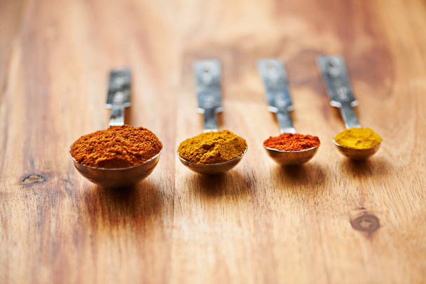 The curry spice range. Closeup shot of different spices in spoons - Фото, изображение