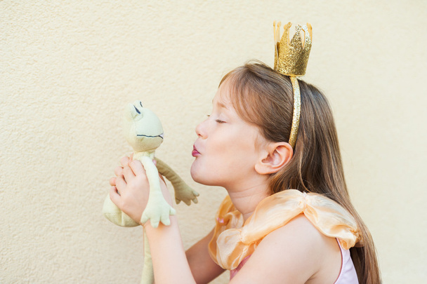 Cute little girl playing with a toy frog, pretending to be a princess - Photo, Image