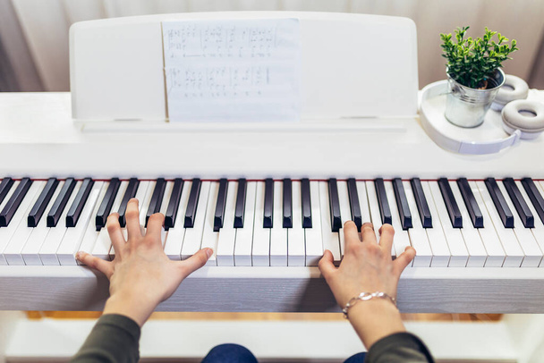 Παιδί που εξασκείται στο σύγχρονο ηλεκτρικό πιάνο στο σπίτι. Μάθημα μουσικής. Κοντινό πλάνο. - Φωτογραφία, εικόνα