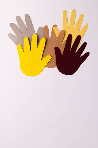 Paper cut out of multi coloured hands with copy space on white background. Humanitarian aid, people, help and human concept. - Zdjęcie, obraz