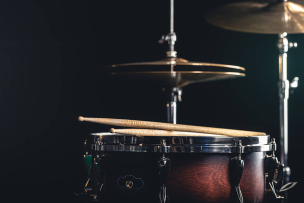 Snare drum and cymbals on a black background, percussion instrument close-up. - Photo, Image