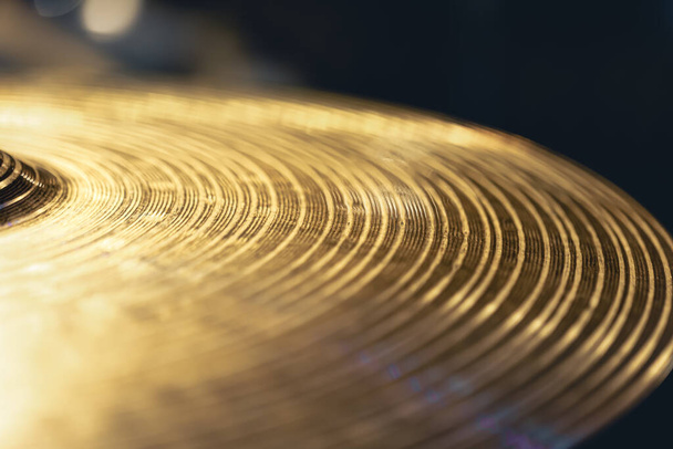 Drum cymbal close-up on a dark background, music concept, macro shot. - Фото, изображение