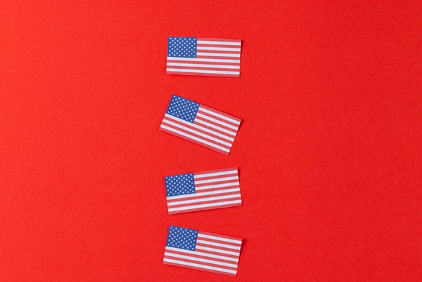 High angle view of four flags of united states of america with copy space on red background. American patriotism, independence day and tradition concept. - Фото, зображення