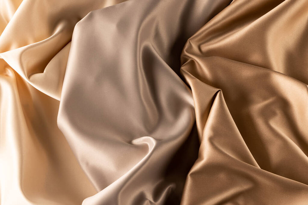 Close up of plain beige satin fabric with folds, copy space. Colour, texture and material. - Fotoğraf, Görsel