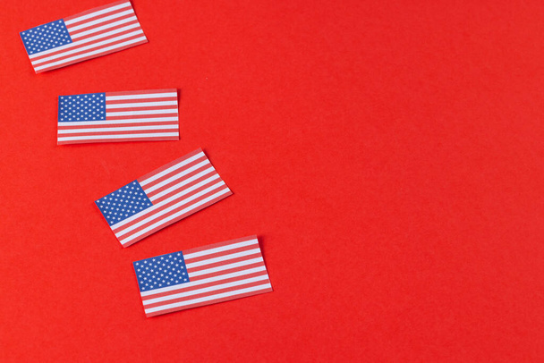 High angle view of four flags of united states of america with copy space on red background. American patriotism, independence day and tradition concept. - Photo, image