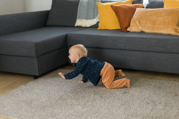Nursery baby crawling on floor indoors at home - Baby curiosity and child development stages - Foto, Imagen