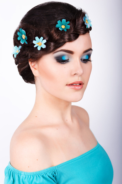 Portrait de mode d'une fille avec un maquillage bleu turquoise vif et des fleurs dans ses cheveux. peau propre
. - Photo, image