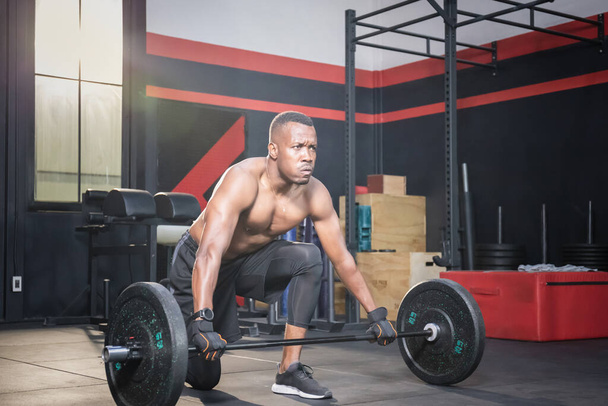 Fitness άνθρωπος άρση βαρών στο γυμναστήριο fitness, μυώδης άνθρωπος που εργάζονται στο γυμναστήριο κάνει ασκήσεις με βάρος barbell - Φωτογραφία, εικόνα