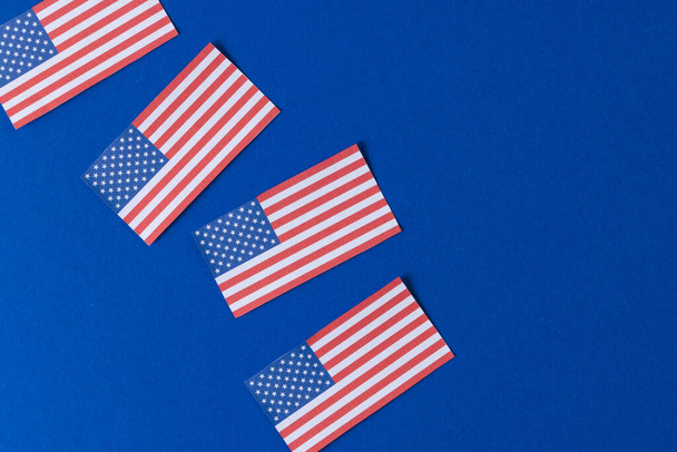 High angle view of four flags of united states of america with copy space on blue background. American patriotism, independence day and tradition concept. - Фото, зображення