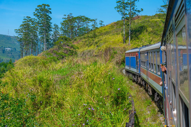 Treno che si snoda su una pista collinare tra piantagioni di tè nello Sri Lanka. - Foto, immagini