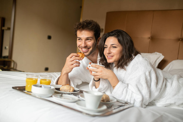 Young couple having breakfast in the bed - Φωτογραφία, εικόνα