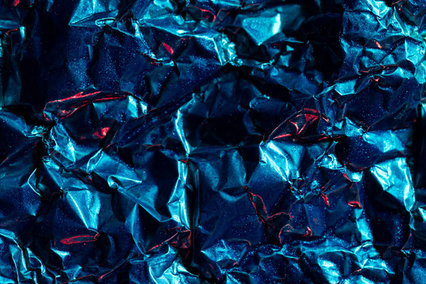 Close up of crumpled shiny blue and red foil with copy space. Colour, texture and material. - Φωτογραφία, εικόνα