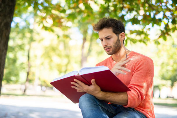 公園で本を読む男性学生 - 写真・画像