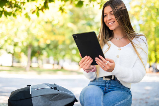 Mujer joven usando una tableta digital al aire libre - Foto, imagen