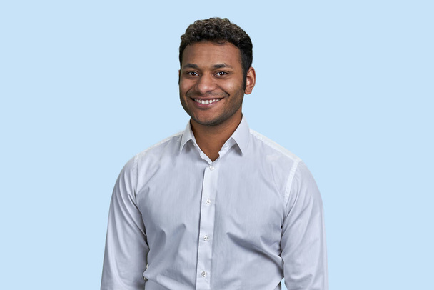 Portrait of a young cheerful indian man smiling with teeth. Isolated on blue background. - Fotografie, Obrázek