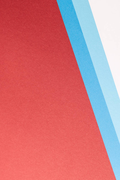 Close up of white and blue paper on red background with copy space. Colour, texture and material. - Foto, Bild