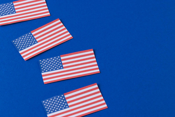 High angle view of four flags of united states of america with copy space on blue background. American patriotism, independence day and tradition concept. - Foto, Imagem