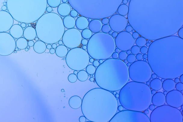 Macro close up of water bubbles with copy space over blue background. Macro, colour, water, shape and pattern concept. - Foto, imagen
