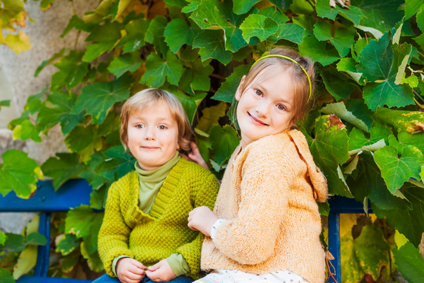 Adorable children resting outdoors, wearing knit pullovers - Photo, Image