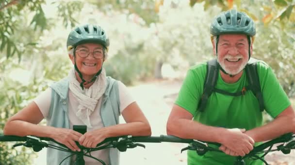 beeldmateriaal van mooi romantisch senior koppel paardrijden fietsen in park - Video