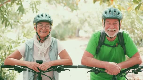 πλάνα από όμορφο ρομαντικό ζευγάρι ηλικιωμένων ιππασία ποδήλατα στο πάρκο - Πλάνα, βίντεο