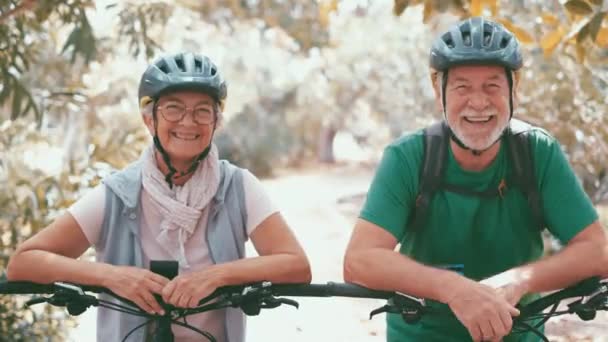 felvétel gyönyörű romantikus idős pár lovaglás kerékpárok a parkban - Felvétel, videó