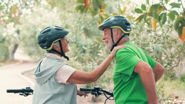 felvétel gyönyörű romantikus idős pár lovaglás kerékpárok a parkban - Felvétel, videó