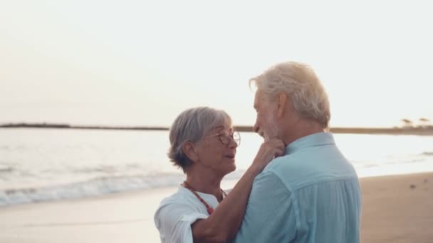 felvétel két boldog és aktív idősről vagy nyugdíjasról, akik jól érzik magukat és élvezik a naplementét mosolyogva a tengerrel - idős emberek a szabadban, akik együtt élvezik a nyaralást - Felvétel, videó