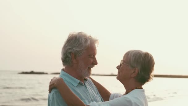 відео двох щасливих і активних літніх людей або пенсіонерів, які розважаються і насолоджуються, дивлячись на захід сонця, посміхаючись морем старі люди на відкритому повітрі насолоджуються відпочинком разом
 - Кадри, відео