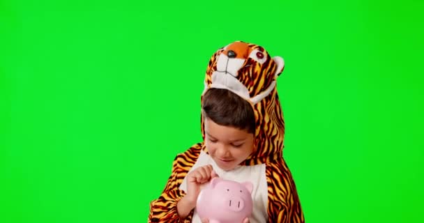 Piggy bank, gezicht en kind in een studio met groen scherm voor sparen, investeren of financieren. Happy, dier kostuum en jongen kid model met een cosplay outfit en geld doos door een chroma key achtergrond - Video