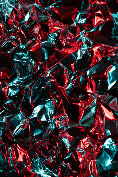 Close up of crumpled shiny blue and red foil with copy space. Colour, texture and material. - Foto, Imagen