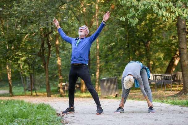nuori pari urheiluvaatteet tekee venyttely harjoituksia puistossa  - Valokuva, kuva