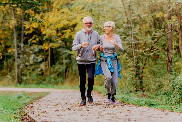 heureux couple aîné jogging dans le parc - Photo, image