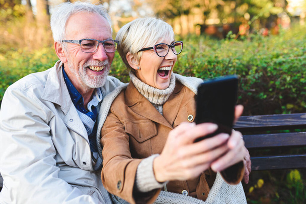 szczęśliwy senior para co selfie w park - Zdjęcie, obraz