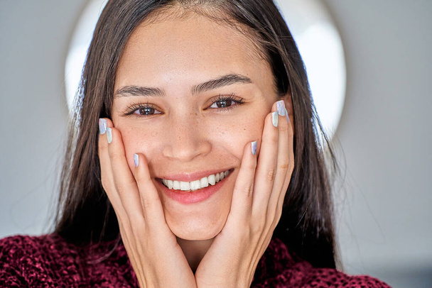 Close-up zicht van een jonge vrouw met kleurrijke manicure nagels kijken naar de camera en glimlachen. Manicure en schoonheidsconcept. - Foto, afbeelding