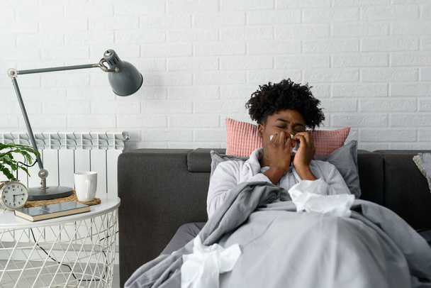 Αφρικανική γυναίκα που πάσχει από γρίπη στο κρεβάτι - Φωτογραφία, εικόνα